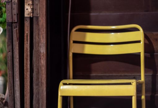 Yellow color steel chair with the old wooden room