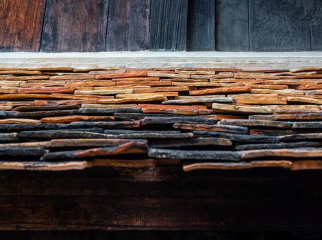 The ancient building roof was shingled with warped clay tiles