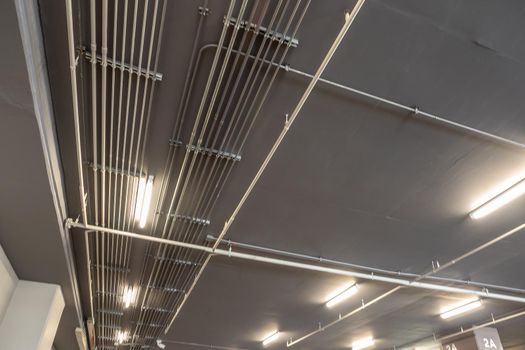 Tidy installation of Galvanized Electrical Metallic Tubing (EMT) Conduits on the ceiling of parking building
