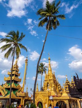 Group of golden pagoda and square hall with a pyramidal roof castle mondop and tiered umbrella Burmese style under the blue sky