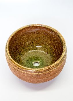 The ceramic cup has been adapted for planting small pot plants