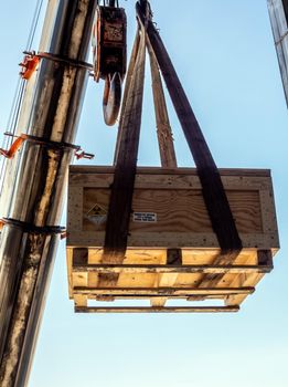 The crane carrying a wooden box of the radioactivity instrument holder transportation wooden box