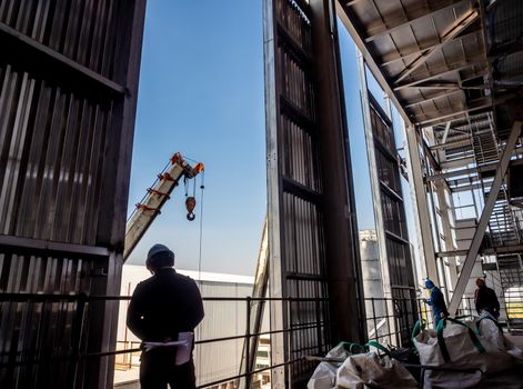 Hoist of crane at the window of industrial plant