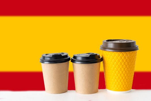 National flag of Spain, on the tablet cup of hot drink coffee or tea on the table.