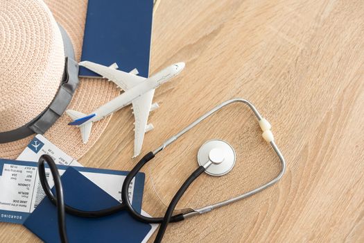 Medical tourism concept. Stethoscope with passport and tickets, toy plane.