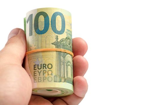 Money in hand isolate on white. The hand holds a roll of 100 euro banknotes. Euro banknotes rolled up in hand isolated on white background. The concept of financial assistance.