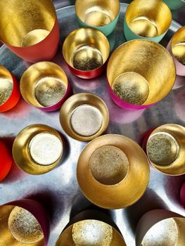 Numerous empty bowls with golden colour inside taken from above