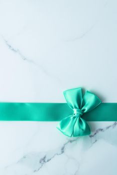 Holiday design, greeting card and vintage gift concept - Green silk ribbon on marble background, top view