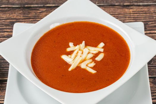 Tomato soup with cheese in white porcelain bowl