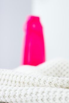 Housekeeping, fabric textures and handmade knitwear concept - Warm knitted clothes and liquid laundry detergent