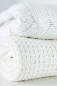 Knitwear, fabric textures and handmade items concept - Warm knitted clothes, soft and white