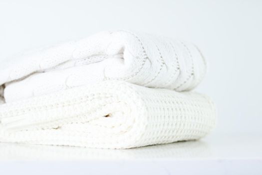 Knitwear, fabric textures and handmade items concept - Warm knitted clothes, soft and white