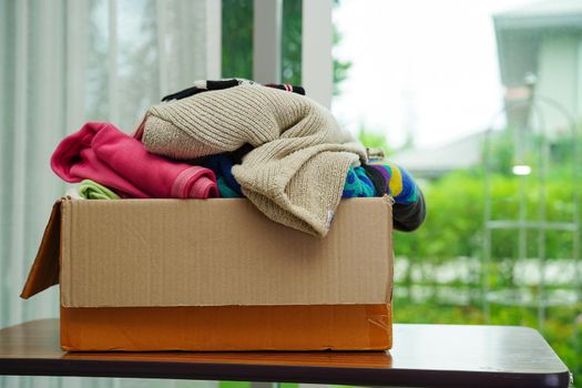 Clothes donations in cardboard box for volunteer.