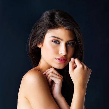 Her beauty is unmatched. Cropped portrait of a gorgeous young woman posing against a dark background