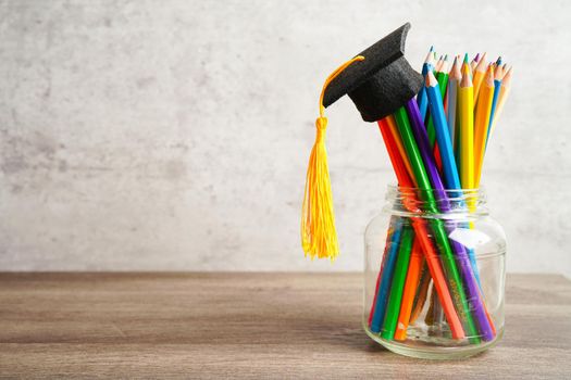Graduation hat with colorful pencils on book with copy space, learning university education concept.