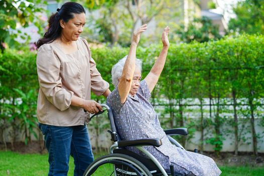 Asian elderly woman disability patient exercise on wheelchair with doctor in park, medical concept.