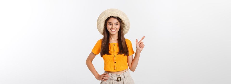 Teenager girl on summer vacation surprised and pointing finger on copy space over isolated white background