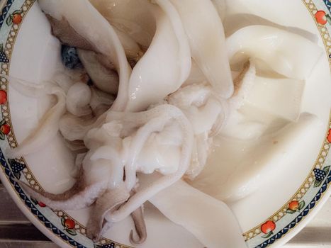 cleaning a raw adriatic cuttlefish at home in Numana, Marche, Italy