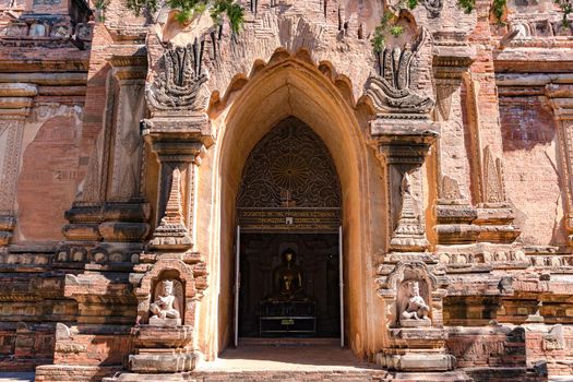 A golden Buddha stands inside the ornate temple complex of Bagan in Myanmar