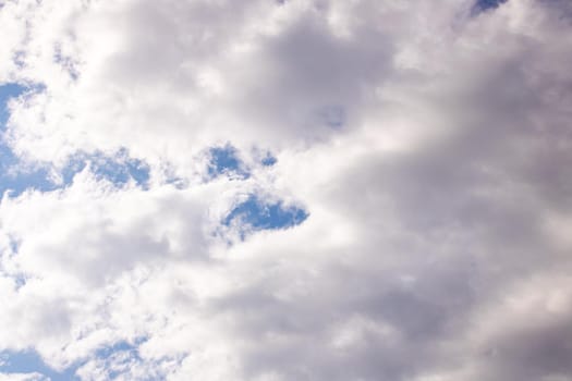 Clouds in the bright blue sky, background or texture