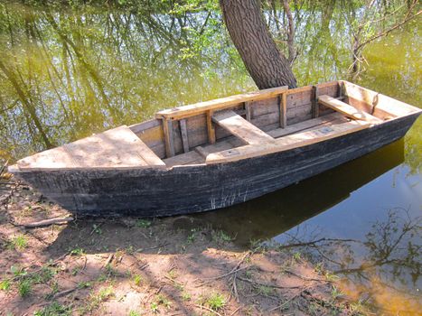 Wooden boat on river coast. Calm Reflection - Beautiful rural Landscape