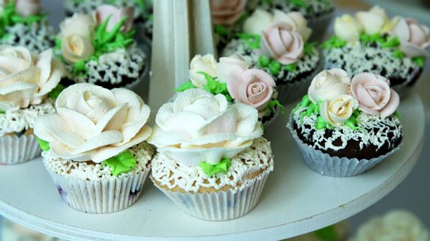 close-up, a variety of delicious desserts, cupcakes, cream cakes, whipped cream, flowers made with cream. festive decor, sweet bar, confectionery masterpieces, treats. High quality photo