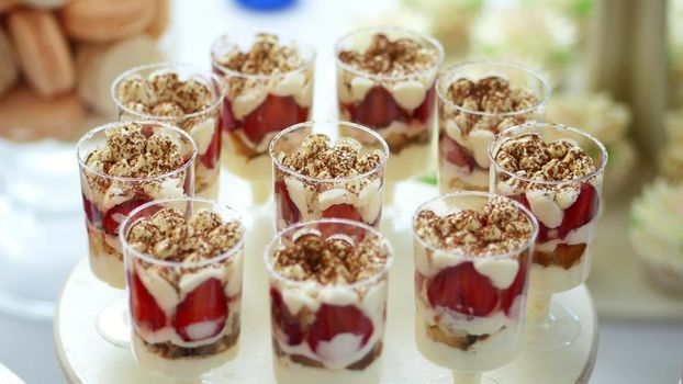 close-up, a variety of delicious desserts, cakes with cream, chocolate and strawberries. whipped cream with cinnamon. festive decor, a sweet bar, a corner, a treat. High quality photo