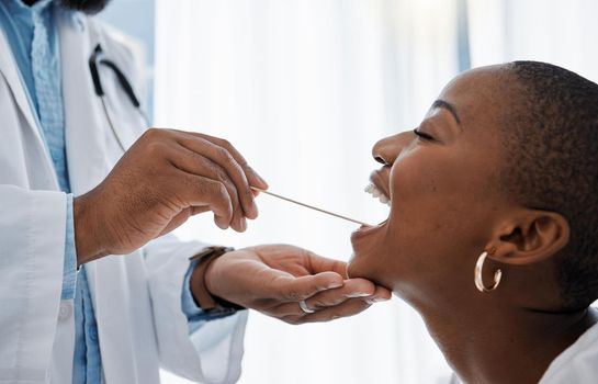 Doctor, otolaryngologist or dentist with a medical instrument checking the throat for tonsils or oral cancer. Health, healthcare worker and wellness with an ent specialist examining a black woman.