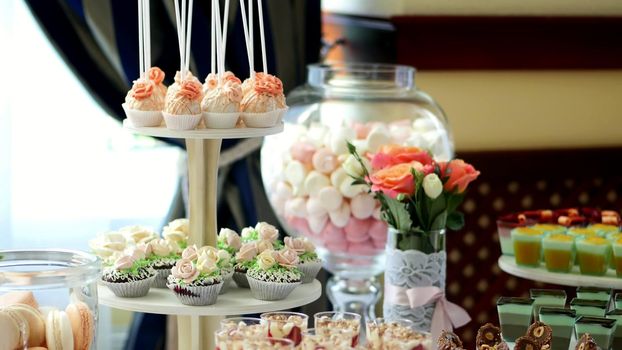 close-up, a variety of delicious desserts, cakes with cream, strawberries, chocolate, under icing , whipped cream, marshmallows, festive decor, sweet bar, corner, a treat. High quality photo