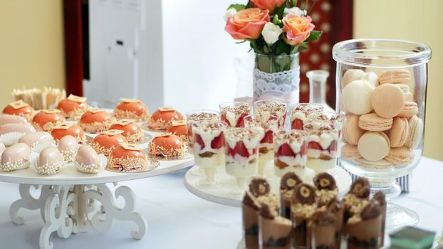 close-up, a variety of delicious desserts, cakes with cream, strawberries, chocolate, under icing , whipped cream, marshmallows, festive decor, sweet bar, corner, a treat. High quality photo