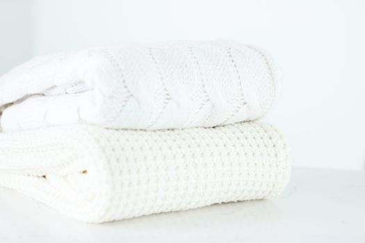 Knitwear, fabric textures and handmade items concept - Warm knitted clothes, soft and white