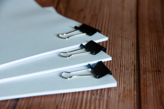Paper stack of clipped pile of documents on wooden desk. Copy space and business offices concept.