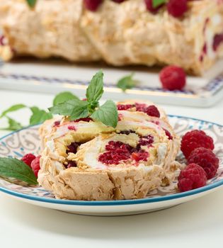 Baked meringue roll with cream and fresh red raspberry, white background