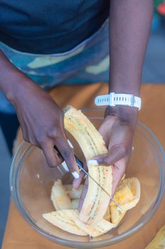 woman chef preparing african caribbean food with plantain plane tree fruit