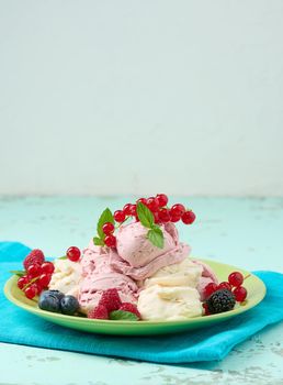 Vanilla ice cream balls with red raspberries in a round plate	