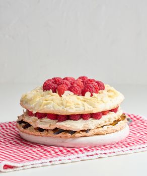 Round meringue pie with fresh raspberries on a white background, Pavlova dessert