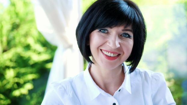 Portrait of pleasant smiling, Happy beautiful real 40 years old Ukrainian woman. a woman drinks tea without taking out a teaspoon. High quality photo