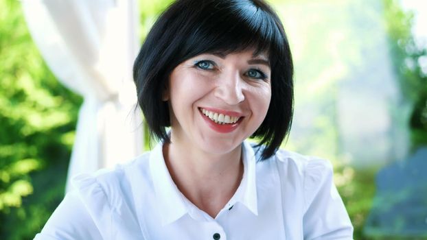 Portrait of pleasant smiling, Happy beautiful real 40 years old Ukrainian woman. a woman drinks tea without taking out a teaspoon. High quality photo