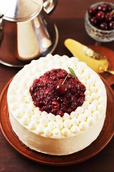 Biscuit cake, cherry souffle with cream cheese and cherry confiture on wooden background. Close-up,vertical photo