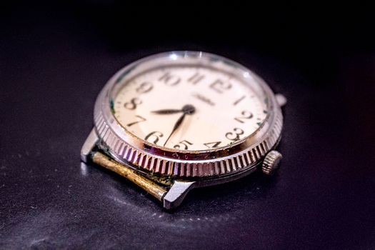 Illustration of the passage of time in an interesting violet tones. Old Wrist Watch on a uniform dark background