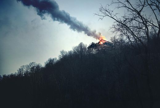 The Burning House in the Mountains, Dusk Landscape with Fire and Smoke on Peak.