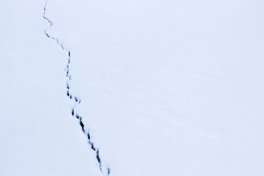 Snow Texture with dark fissure of ice on river, Nature Snow Surface in sunny day