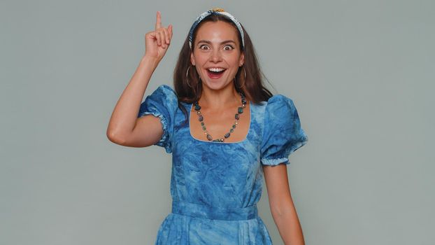 Eureka. Inspired woman pointing finger up with open mouth, having good idea, plan, startup, showing inspiration motivation gesture, problem solution. Adult stylish girl on gray studio background