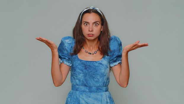Why, what. Pretty young woman raising hands in indignant expression, asking reason of failure, demonstrating disbelief irritation by troubles. Adult stylish girl isolated on gray studio background
