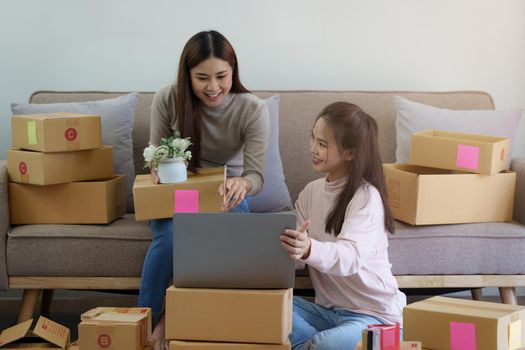 Two Asian SME business woman working at home office. online shopping concept.