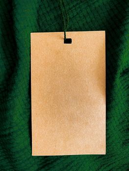 Blank fashion label tag, sale price card on luxury fabric background, shopping and retail concept