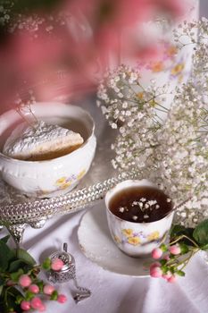 white still life with cheesecake gypsophila and cup of tea, light and airy, High quality photo,table setting for tea drinking in the English style
