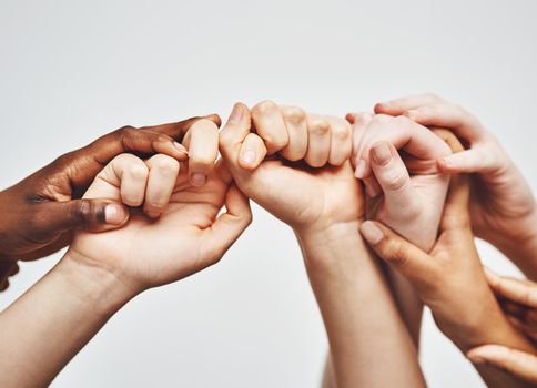 Hold on just a little longer. a group of hands holding onto each other against a white background