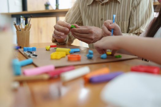 Adorable little girl and father playing with colorful plasticine. Handmade skills training.