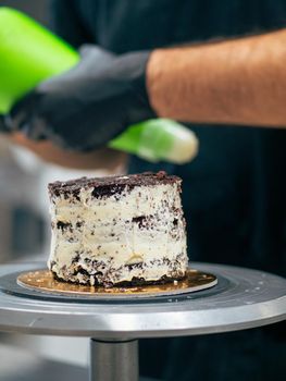 professional baker decorating a chocolate and cream cake with salty caramel